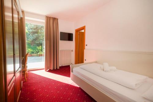 pokój hotelowy z łóżkiem i dużym oknem w obiekcie Hotel Marlingerhof w mieście Marlengo