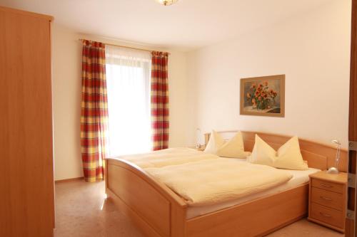 a bedroom with a bed and a window at Dangl GbR, Gästehaus Sonnenhof - inkl. Chiemgau Karte in Bergen