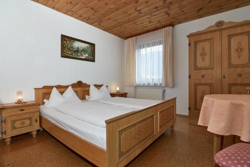 a bedroom with a large bed and a window at Dangl GbR, Gästehaus Sonnenhof - inkl. Chiemgau Karte in Bergen