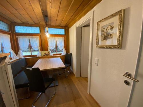 a dining room with a table and chairs and windows at Ferienwohnungen Mikula-Hubacek in Bad Aussee