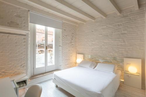 a bedroom with a white bed and a window at Scaravelli Residenza in Mantova