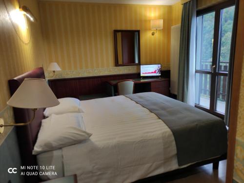 a hotel room with a bed and a desk with a laptop at Val Del Rio in Fiumalbo