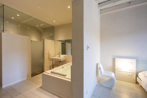 a bathroom with a tub and a toilet and a sink at Scaravelli Residenza in Mantova