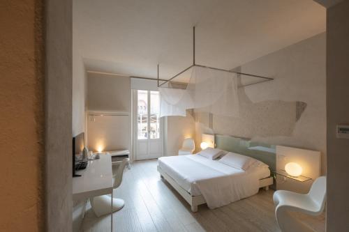 una camera con letto, scrivania e sedia di Scaravelli Residenza a Mantova