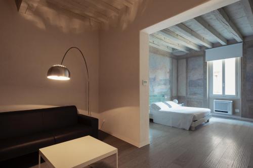 a bedroom with a bed and a couch at Scaravelli Residenza in Mantova