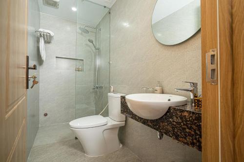 a bathroom with a toilet and a sink and a shower at Sline Hotel in Hue