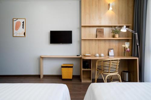a hotel room with a desk and a tv at Sline Hotel in Hue