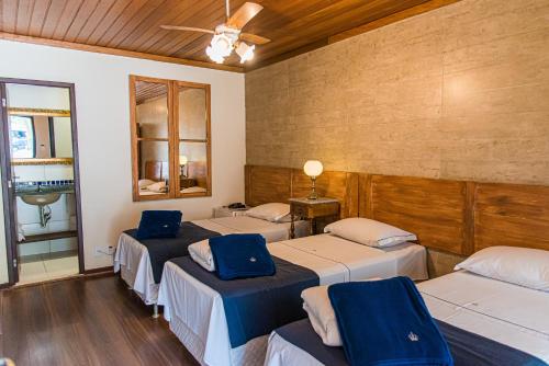 um quarto com 3 camas e uma ventoinha de tecto em Pousada Dom Petrópolis em Petrópolis