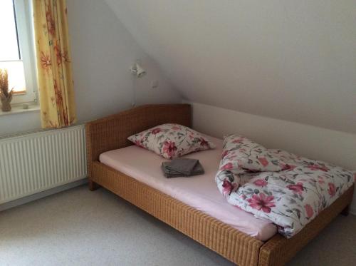 ein kleines Bett mit zwei Kissen darauf in einem Zimmer in der Unterkunft Ferienwohnung am Mühlendamm in Lastrup