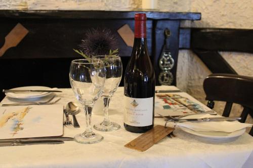 a bottle of wine sitting on a table with a glass at The Upper Largo Hotel & Restaurant in Lundin Links