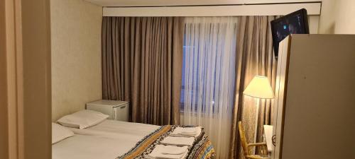 a hotel room with a bed and a window at Hotelli Sandels in Siilinjärvi