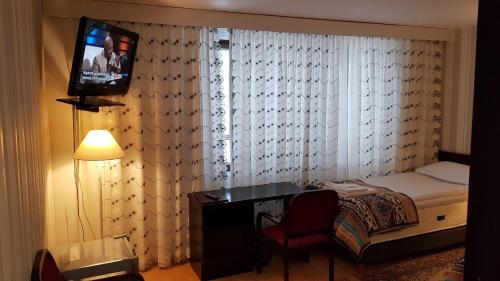 a bedroom with a bed and a television in a room at Hotelli Sandels in Siilinjärvi