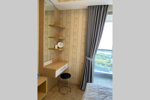 雅加達的住宿－Studio Apartment - Gold Coast PIK, Jakarta Utara，卧室设有窗户、书桌和椅子