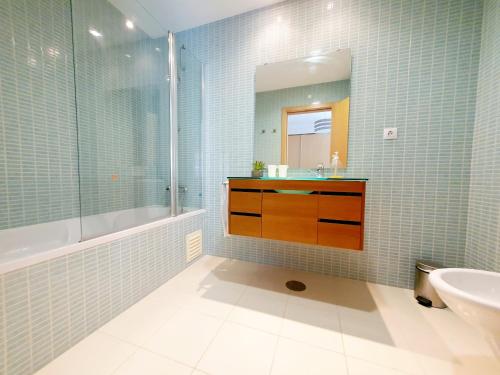 La salle de bains est pourvue d'un lavabo, d'une baignoire et d'un miroir. dans l'établissement Sovipral Homes Casa Marina, à Olhão