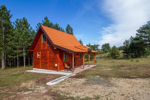 a small cabin with an orange roof in a field at Brvnara Kovacevic in Zlatibor