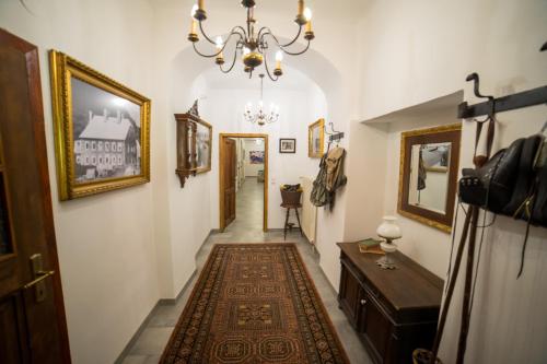 a hallway with a rug and a chandelier at Pension Polsterrinne in Sankt Lorenz