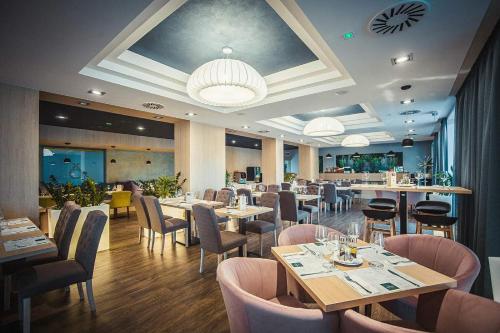 a restaurant with tables and chairs and a bar at Portofino Apartman in Sárvár