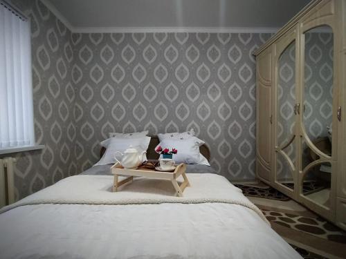 a bedroom with a bed with a table on it at 2 комнатная в микрорайоне Шугыла in Qyzylorda