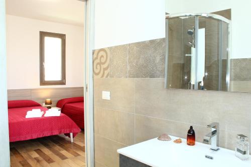 a bathroom with a sink and a red couch at Suite Capaci in Capaci