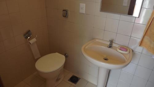 a bathroom with a toilet and a sink at Alugo quarto com internet in Porto Alegre