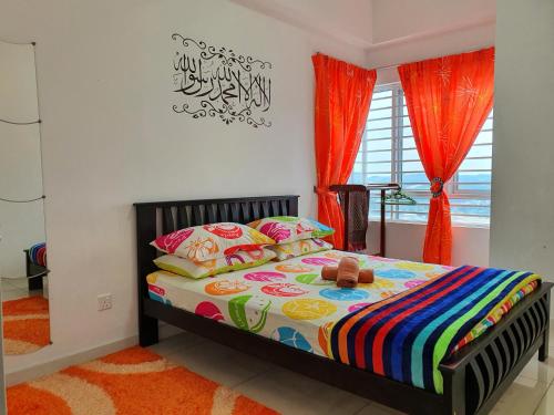 a bedroom with a bed with colorful blankets and pillows at AZ Homestay @ Southville City in Bangi
