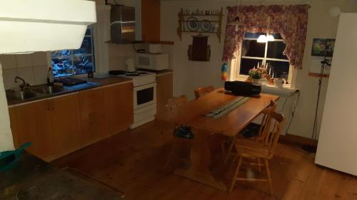 a kitchen with a wooden table and a kitchen with a window at Romme Rum in Borlänge