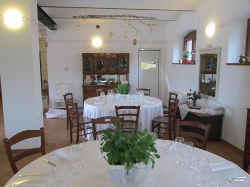 a dining room with white tables and chairs at Agriturismo Antica Corte Contadina in Premariacco