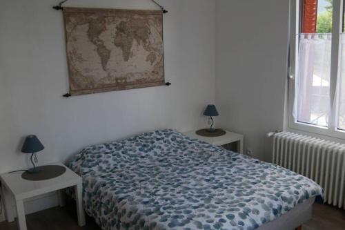 een slaapkamer met een bed, 2 tafels en een raam bij T2 proche du lac in Aix-les-Bains