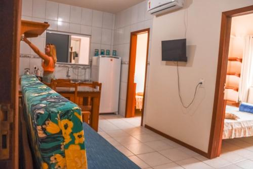 een vrouw in een keuken met een koelkast bij Pousada Pegadas na Areia in Palhoça