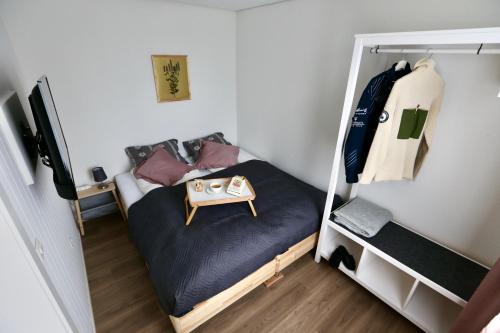 a small room with a bed with a table on it at ALP APARTMENTS centre location with traditional design and self check-in in Engelberg