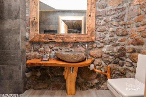 a stone bathroom with a sink and a mirror at Stone house in Prapuntai