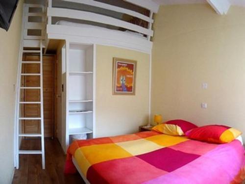 a bedroom with a colorful bed and a ladder at Résidence Thibaud in Toulouse