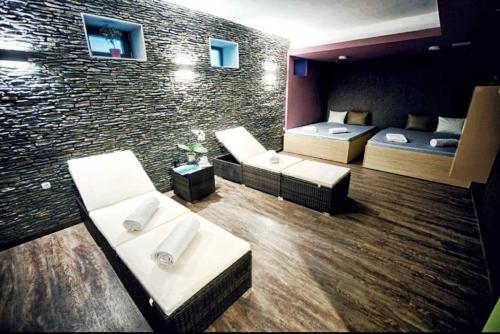 a room with two beds and a brick wall at Portofino Apartman in Sárvár