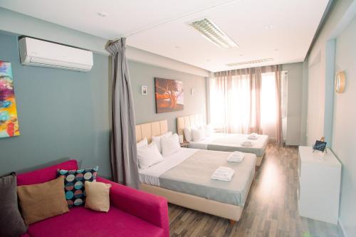 pokój hotelowy z 2 łóżkami i kanapą w obiekcie Ermou Downtown Studios by Hospitality Box w Atenach