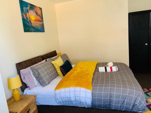 a bedroom with a bed with a yellow blanket at Pine Lodge in Gillingham