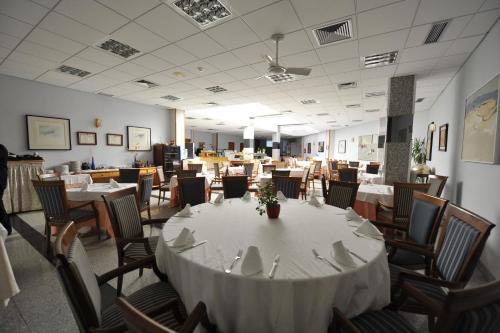 a dining room with a white table and chairs at Puerta de Segovia in La Lastrilla