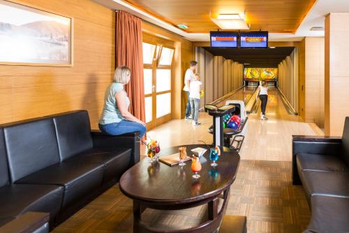 a woman sitting on a couch in a living room at Hotel OTP Birkenhof in Bad Kleinkirchheim