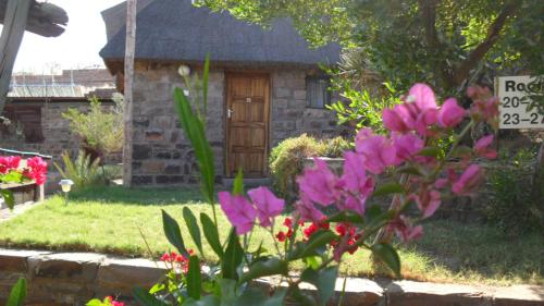 a garden with pink flowers in front of a house at Seeheim Hotel in Seeheim
