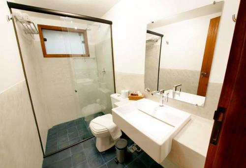 a bathroom with a sink and a toilet and a mirror at Pousada Villa Maeva Itacare in Itacaré