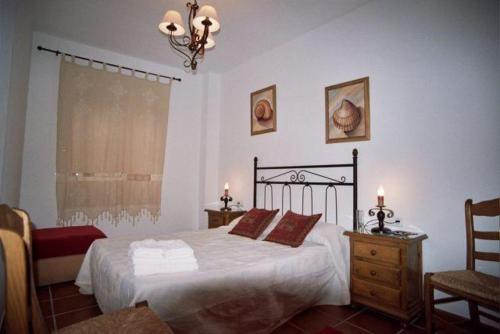 een slaapkamer met een bed, 2 tafels en een raam bij Casa María en el centro Nerja in Nerja