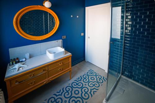 Baño azul con lavabo y espejo en The Lion's Den BnB en Trieste