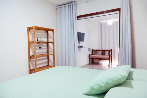 - une chambre avec un lit et une chaise dans l'établissement RESIDENCIAL FLATS ANGELIM I - TÉRREO , 2 QUARTOS com AR, CENTRO, à Itacaré