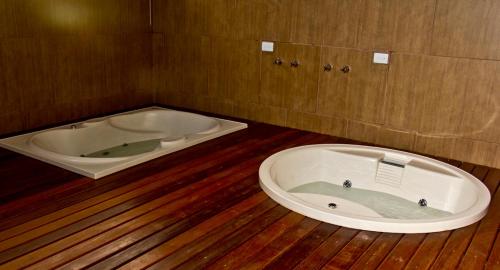a jacuzzi tub in a room with a wooden floor at Monte Serrat Hotel in Santos