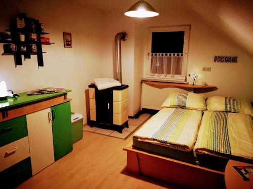 Home Nicoletta في Spechtsbrunn: غرفة نوم صغيرة بها سرير ومطبخ