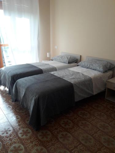 3 camas en una habitación con ventana en LOCANDA CAVALLO BIANCO - AFFITTACAMERE en Robella