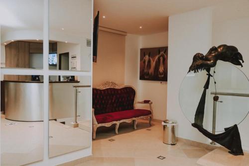 a living room with a chair and a large mirror at HOTEL GRAND BOUTIQUE in Fusagasuga