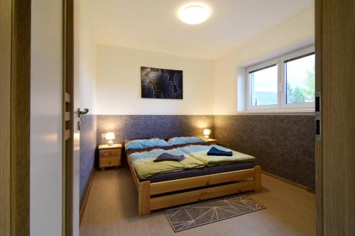 a bedroom with a bed and a window at Bungalov v Beskydech in Frenštát pod Radhoštěm