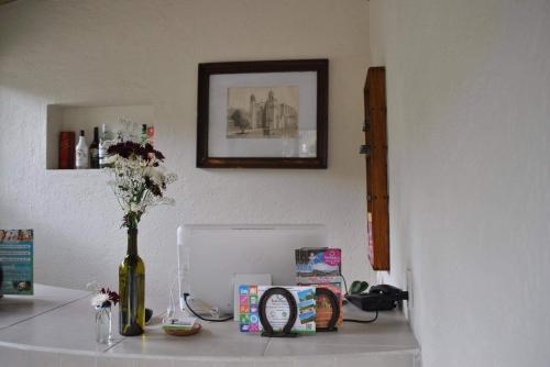 uma mesa com um vaso de flores e uma garrafa de vinho em El Amate em Tepoztlán