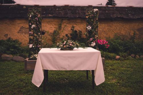 a table with a white table cloth and flowers on it at Zámek Ruda nad Moravou in Ruda na Moravě