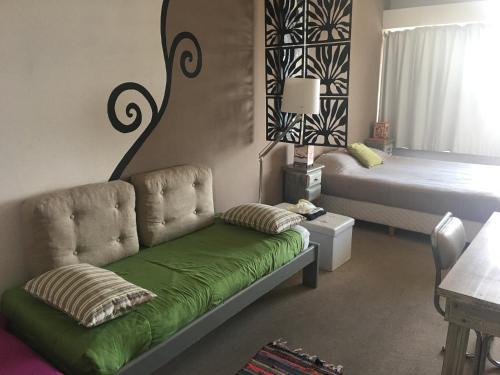 uma sala de estar com um sofá e uma cama em Vista Al Lago Apartments em San Carlos de Bariloche